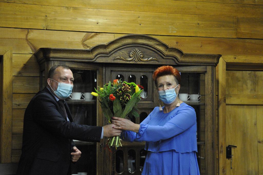 Spotkanie jubileuszowe - burmistrz Ryglic Paweł Augustyn wręcza kwiaty dyrektor