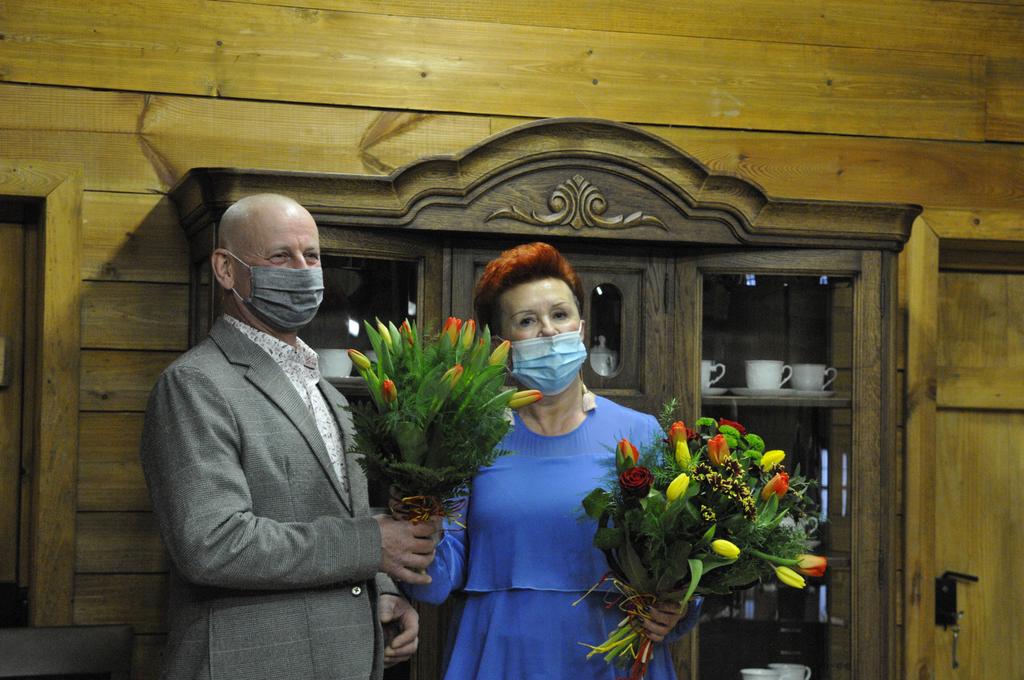 Spotkanie jubileuszowe - przedstawiciel rady miejskiej w Ryglicach Tadeusz Augustyn wręcza kwiaty dyrektor 